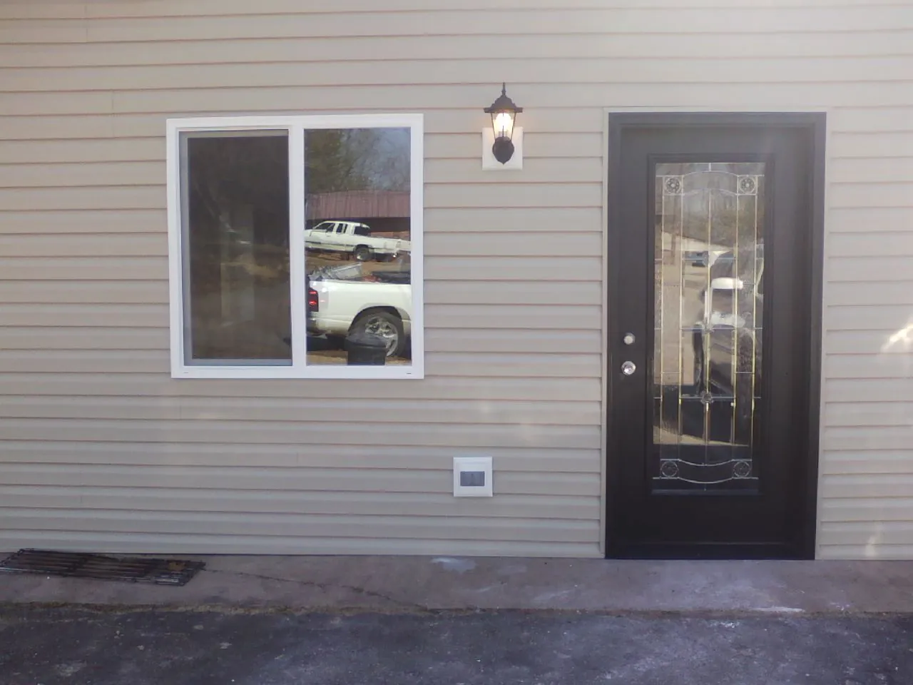 New siding, window and entry door on the side of an addition in West Point